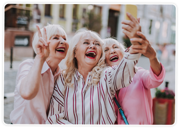 Happy mature woman taking a selfie with friends